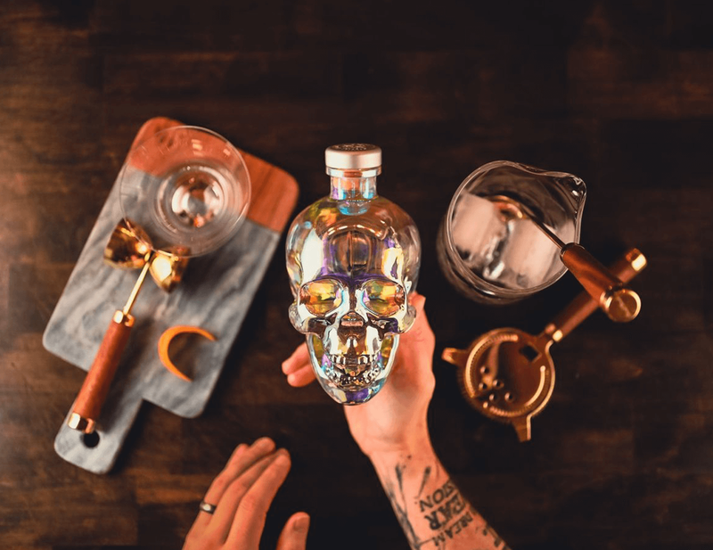 Aurora Crystal Head Vodka is held up with a making a cocktail